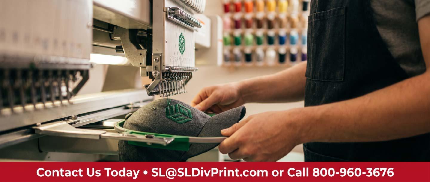 Commercial embroidery machine stitching a green logo onto a charcoal hat during a 48 hour embroidery rush order at a boutique print shop. rush printing service, same day order turnaround, boutique print shop, 48 hour embroidery, trade show banner deadline, custom check vendor, human proofing support, guaranteed delivery date, Scottsdale promotional products, nationwide fulfillment partner, screen printed apparel
