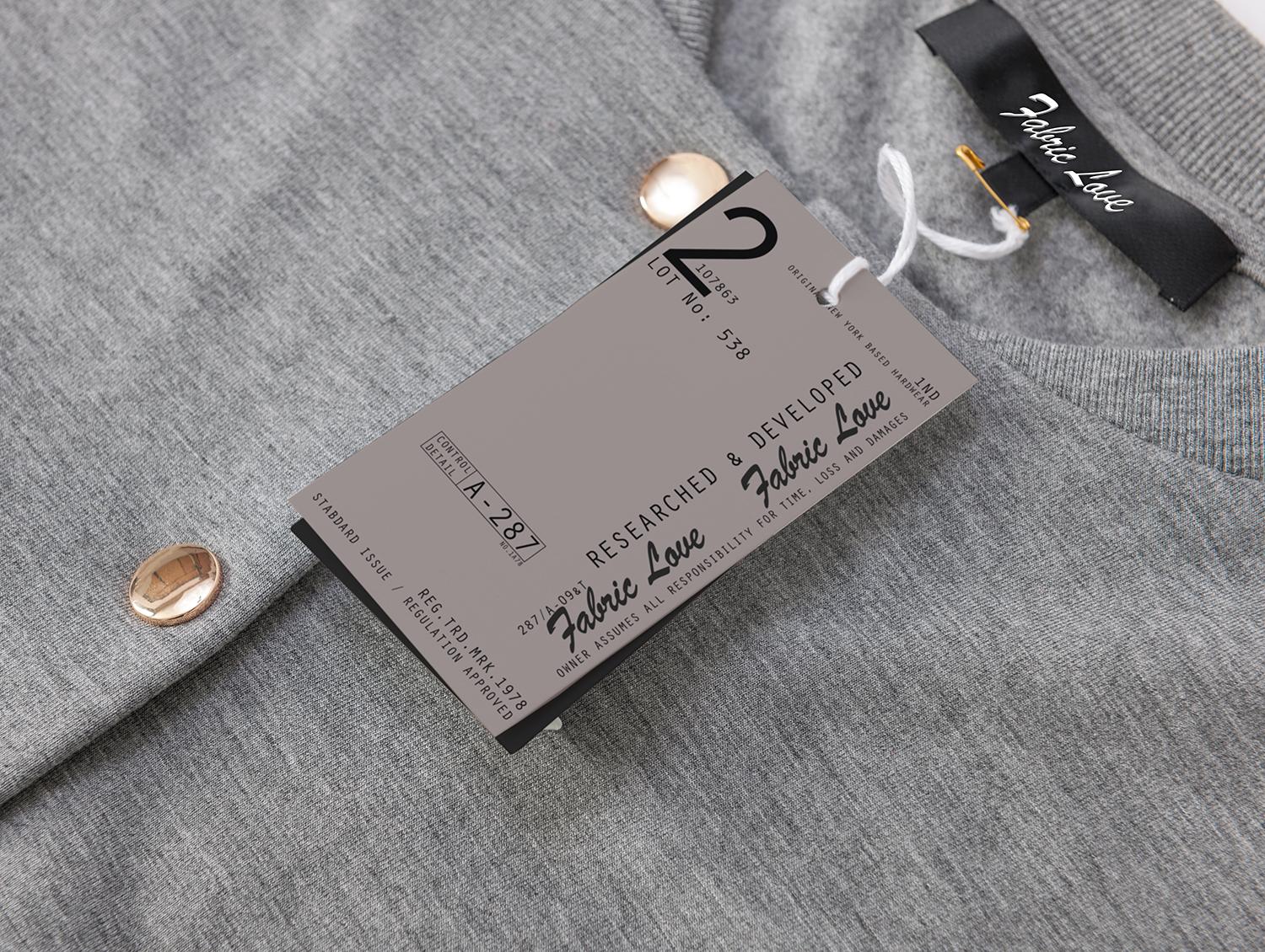 Gray knit garment with a white string tag reading Fabric Love attached to the fabric