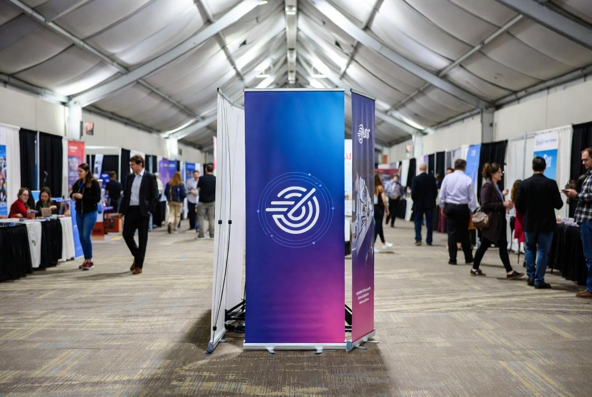 DoubleSided Retractable Banner Stand 360° Visibility | SL Diversified Printing double sided retractable banner stand in convention center hallway delivering 360 degree brand messaging